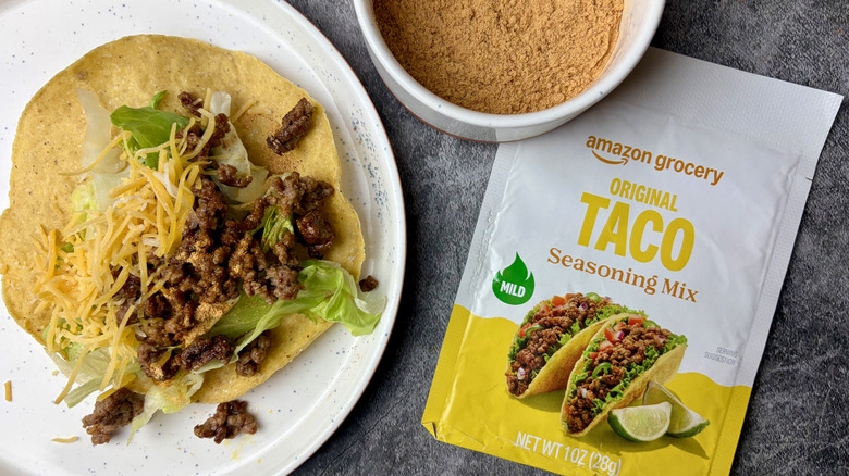 Amazon Grocery Mild Taco Seasoning Mix packet, seasoning in a white ramekin, and a taco on a white plate