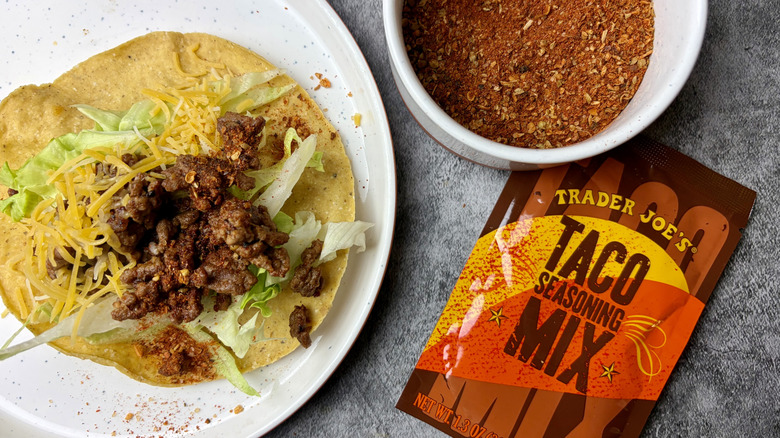 Trader Joe's Taco Seasoning Mix packet, seasonings in a white ramekin, and taco on a white plate