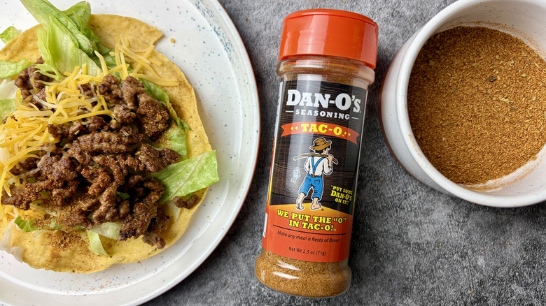 Dan-O's Premium Blends Tac-O Seasoning bottle, seasoning in a white ramekin, and taco on a white plate