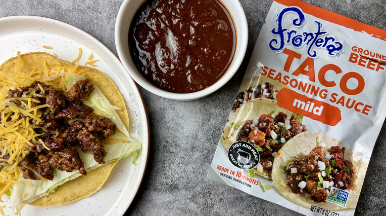 Frontera Mild Taco Seasoning Sauce packet, sauce in a white ramekin, and taco on a white plate