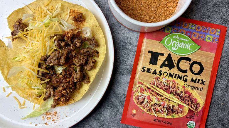 Wegmans Organic Original Taco Seasoning Mix packet, seasoning in a white ramekin, and taco on a white plate