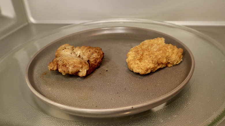 two chicken tenders on plate in microwave