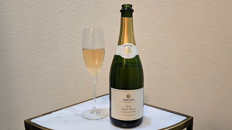 Trader Joe's North Coast Brut Sparkling Wine and glass on a marble counter