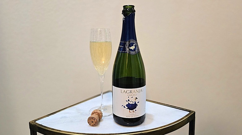 La Granja 360 Brut Cava next to a cork and a glass filled with sparkling wine