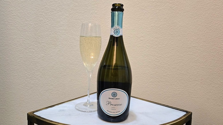 Trader Joe's Prosecco D.O.C. next to a glass filled with sparkling wine