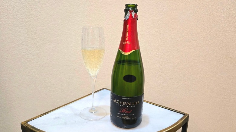 M. Chevallier Carte Noire Brut Cava and glass on a marble table against a beige background