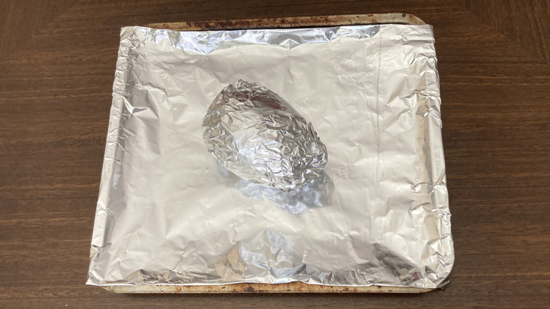 An avocado in foil on a pan