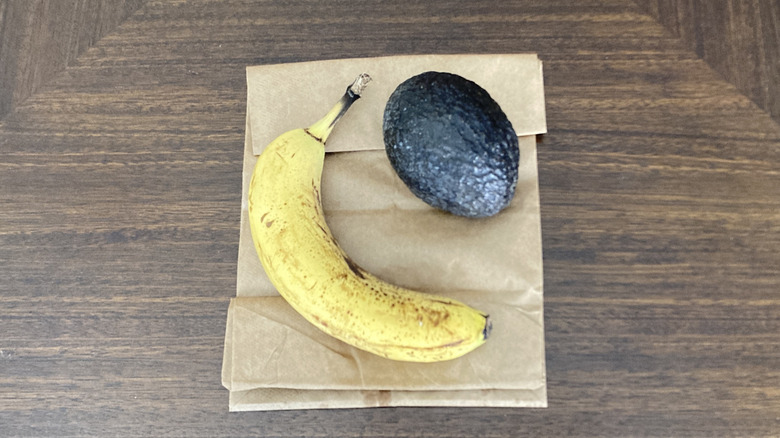 A banana and an avocado on a paper bag