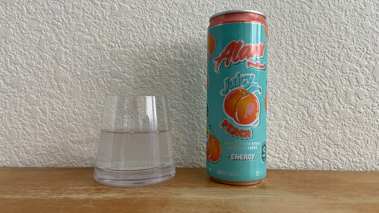 Juicy Peach can beside some poured into a small glass