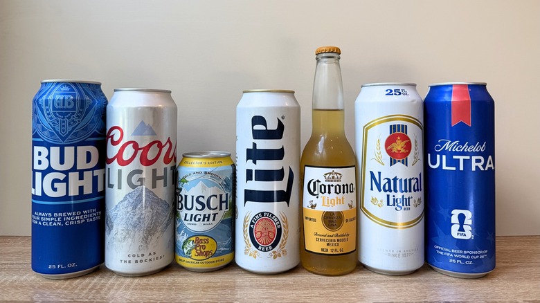 A lineup of seven beers including Bud Light, Coors Light, Busch Light, Miller Lite, Corona Light, Natural Light, and Michelob Ultra in a mix of cans and a bottle