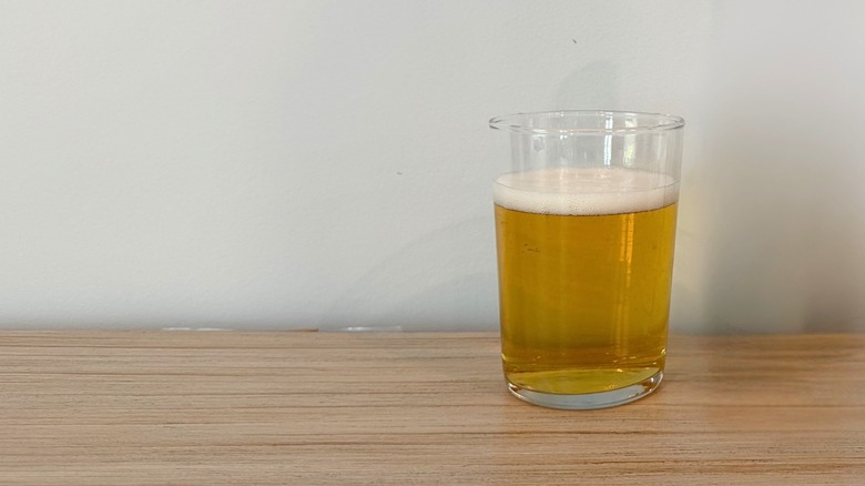 A glass of pale golden beer topped with a thin foamy head