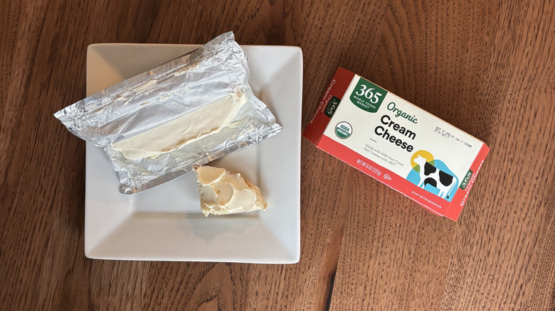 Bagel quarter with cream cheese spread and a block of cream cheese