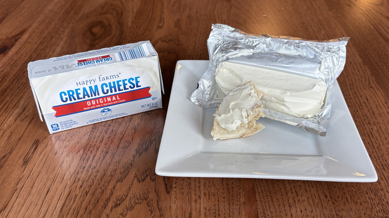 Box of cream cheese and bagel with cream cheese spread on top