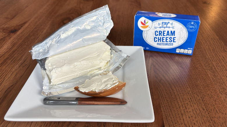 Block of cream cheese with bagel topped with cream cheese and box next to it