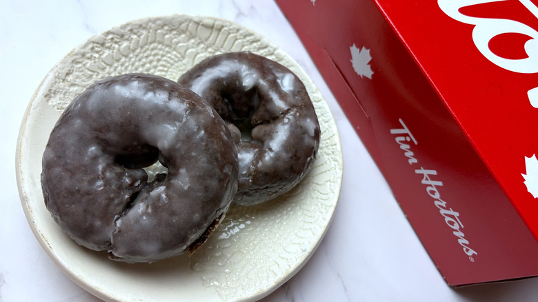 Two Tim Hortons Chocolate Glazed Donuts on a white plate