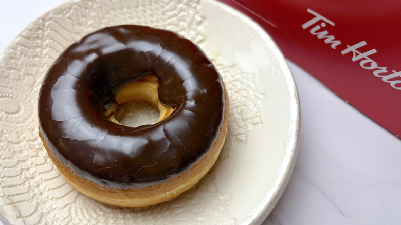 A Tim Hortons Chocolate Dip Donut on a white plate