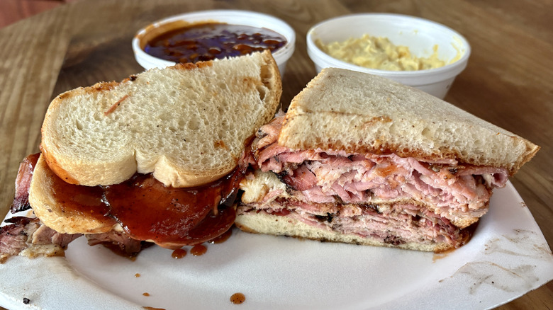barbecue sandwich with beans and potato salad in background