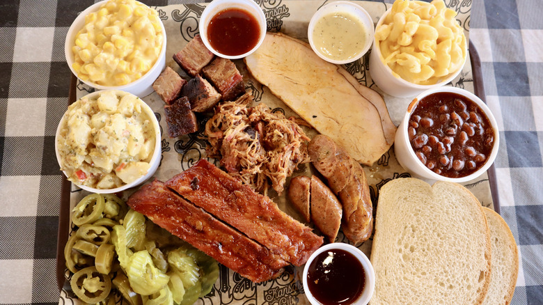 overhead view of barbecue tray with ribs, turkey, pulled pork, beans, and more