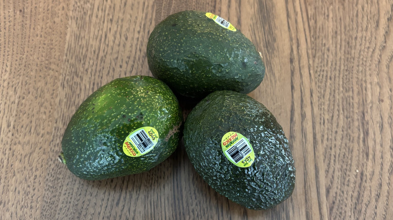 three avocados on table