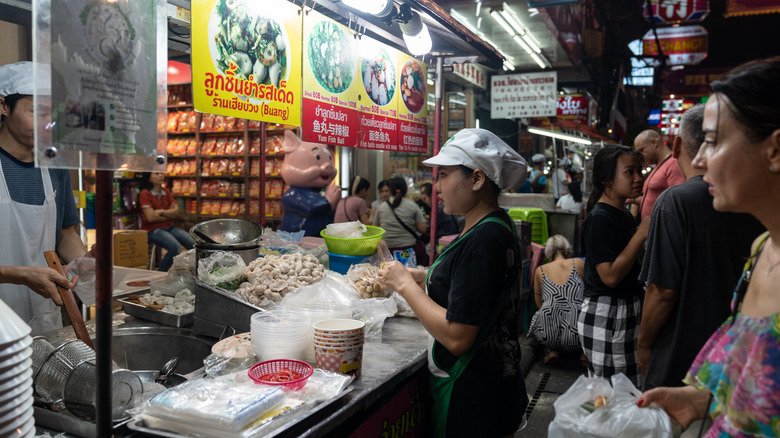 Street food vendors sell food from a cart