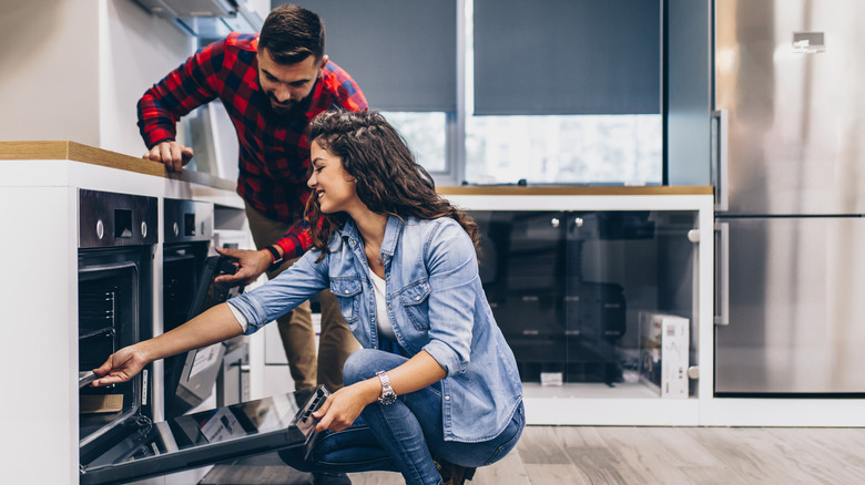 Man and woman looking in open oven