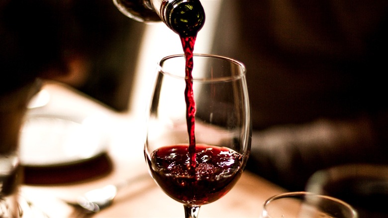 Red wine being poured into a glass.