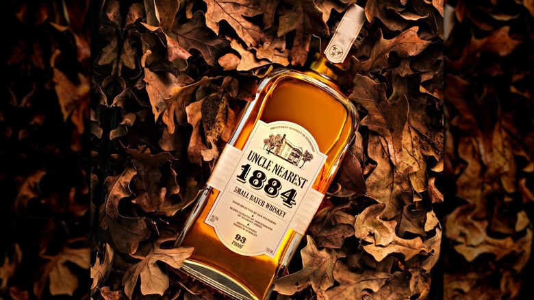 Bottle of Uncle Nearest 1884 laying in autumn leaves