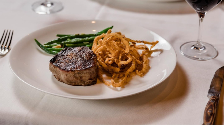 cooked steak with sides and wine