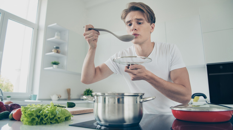 Person tasting pot of soup