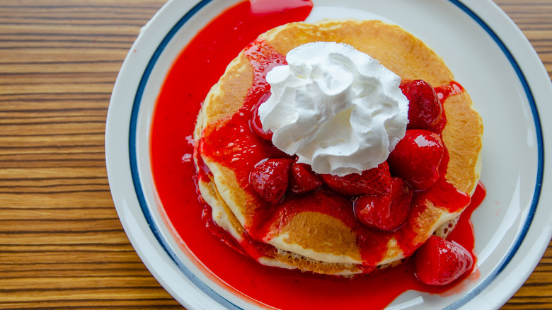 Pancakes with strawberry topping and whipped cream
