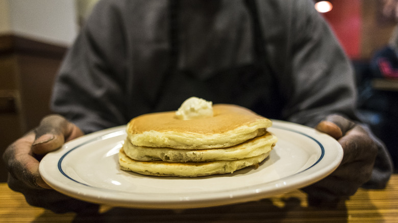 A plate of pancakes topped with butter.