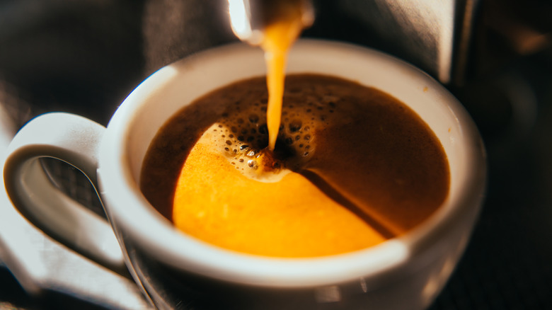 closeup of coffee being poured into a cup
