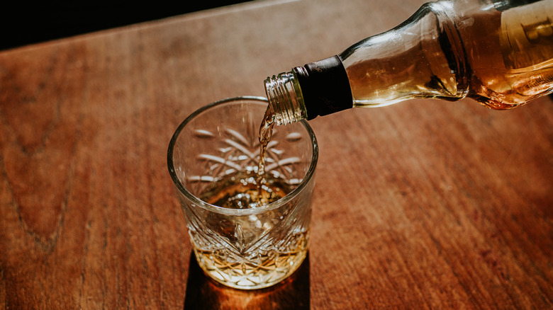 pouring a glass of whiskey