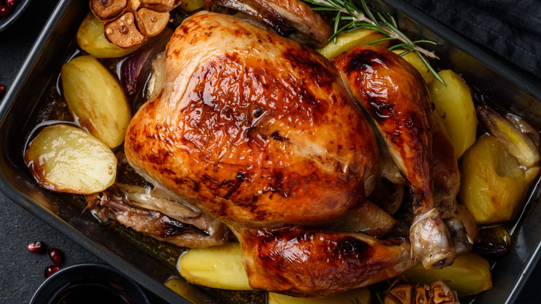 Roasted turkey in a pan with potatoes