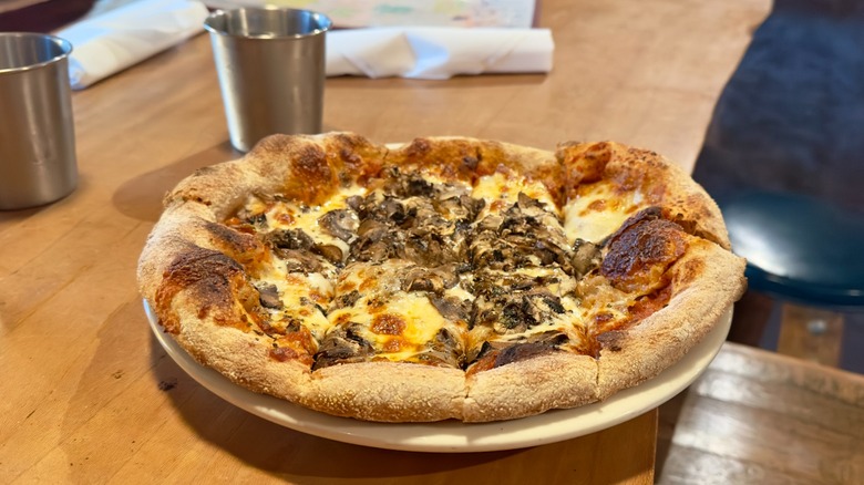 Flatbread with mushrooms and cheese on restaurant table.