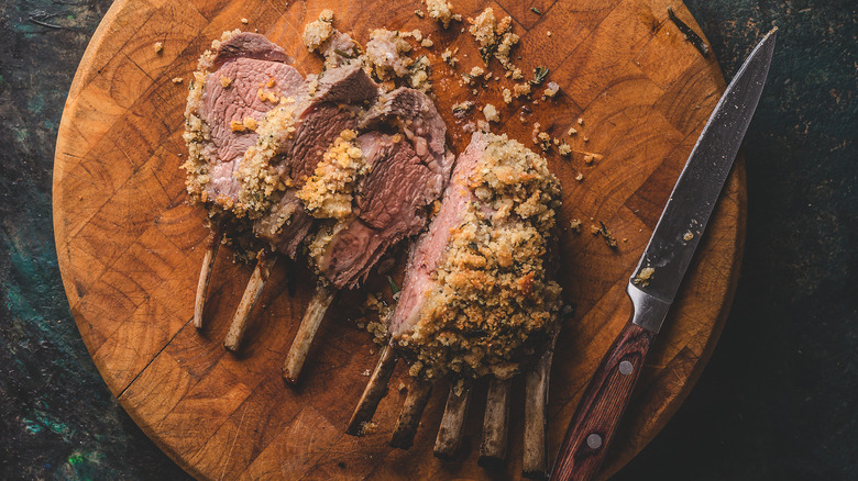 Sliced rack of lamb on wooden tray