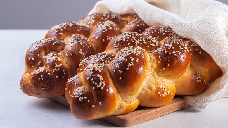 Challah bread in cloth sack on cutting board