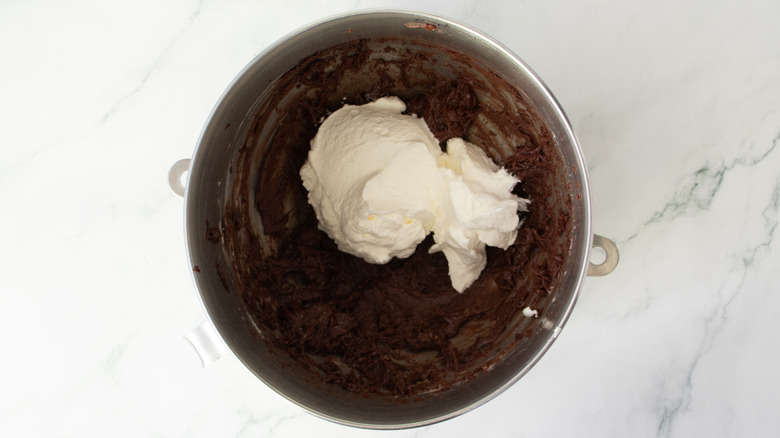 chocolate frosting with whipped cream on top