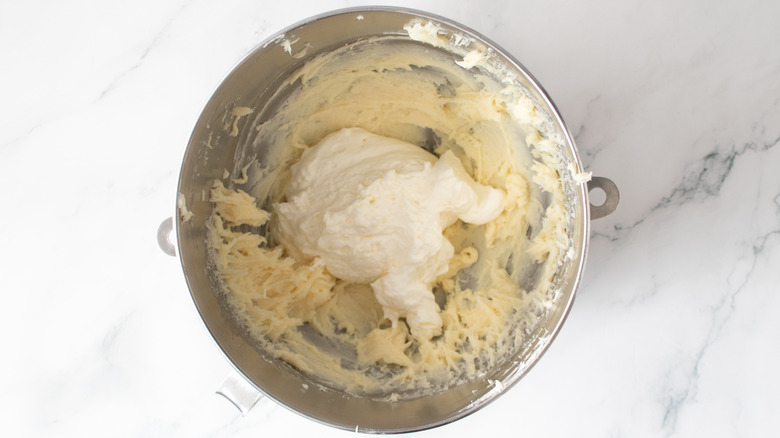 white frosting and whipped cream in a metal bowl