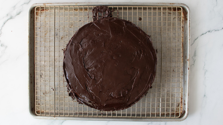 chocolate-frosted cake on a metal rack