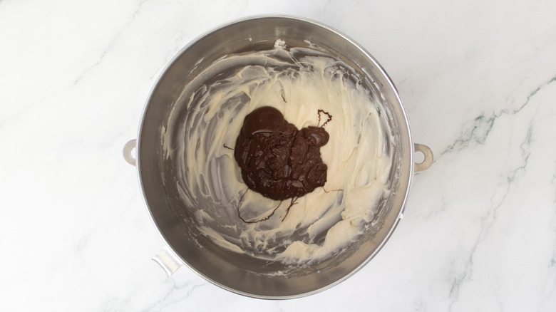 white frosting with melted chocolate on top