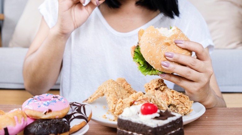 woman eating chicken, burgers, donuts, etc.