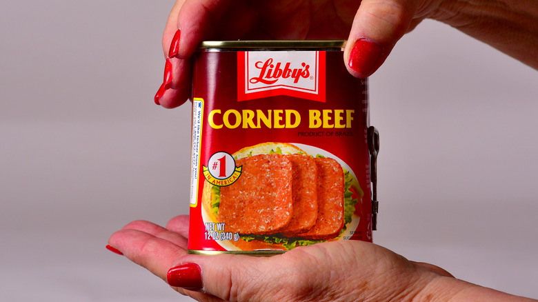 Hands holding Libby's corned beef