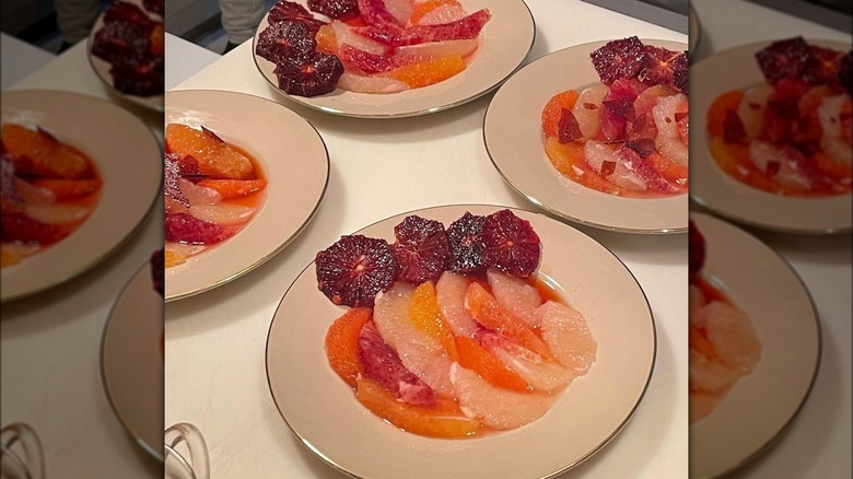 Multicolored oranges on white plates