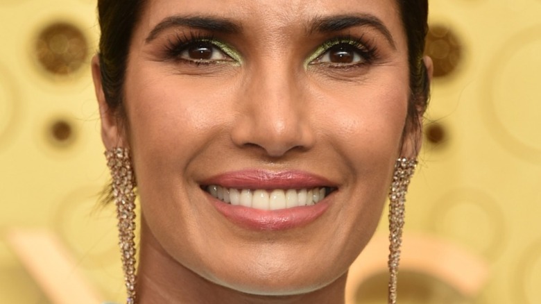 Padma Lakshmi with hair pulled back and wide smile