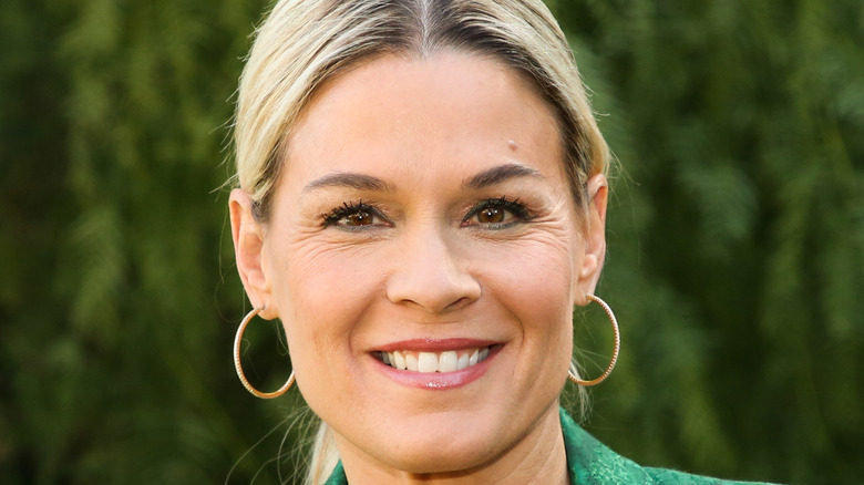 Cat Cora in gold hoops and green jacket
