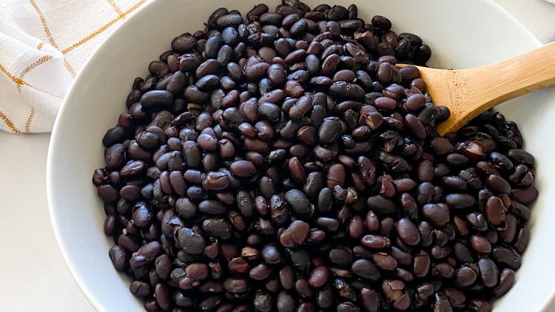 wooden spoon in bowl of black beans