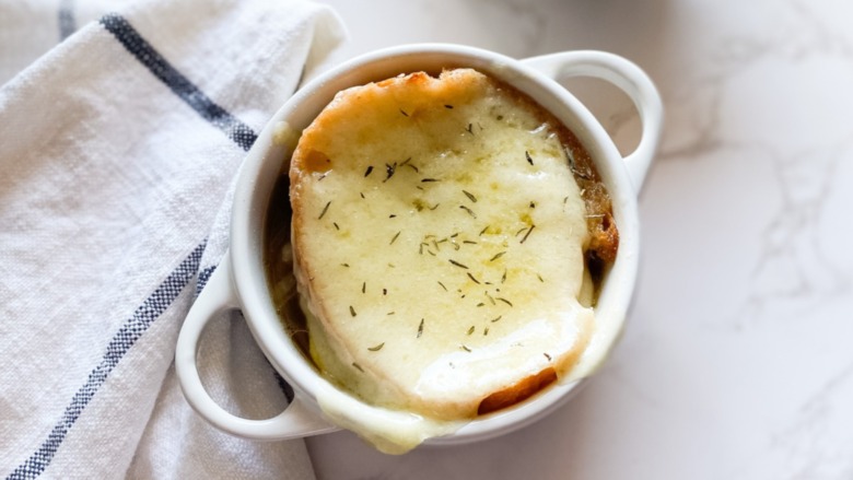 French Onion Soup in a ramekin with a cloth napkin beside it