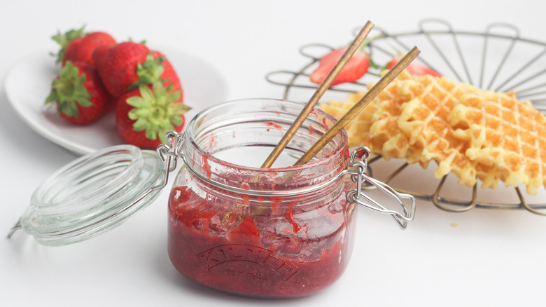 Strawberry compote in a jar with waffles
