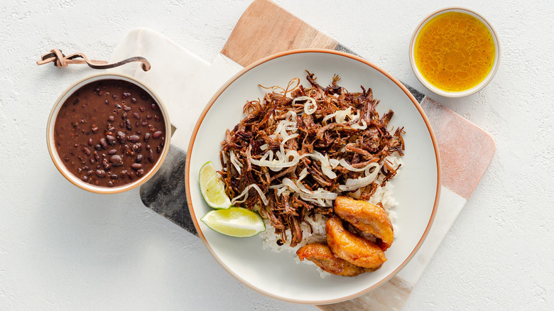 plate of instant pot vaca frita with bowl of beans